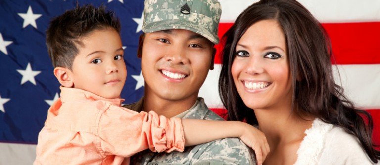A veteran and his family in front of an American flag