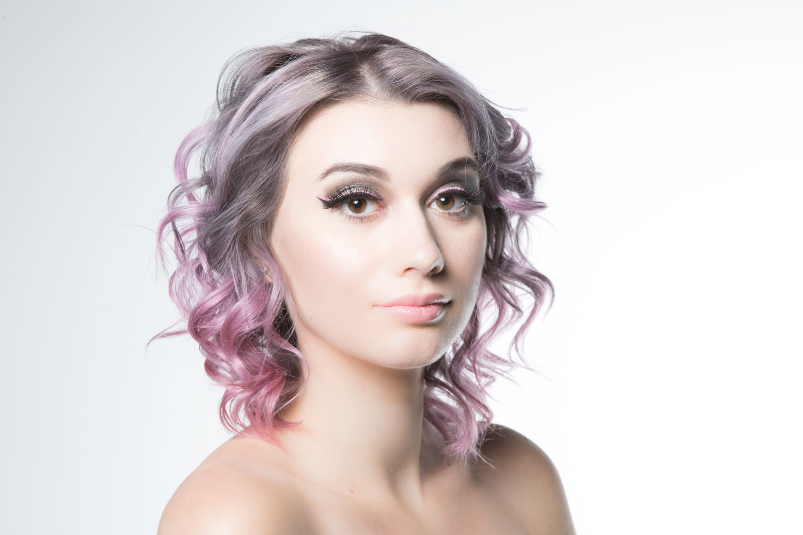 Model with shoulder-length wavy silver-lilac hair fading into pink at the ends.