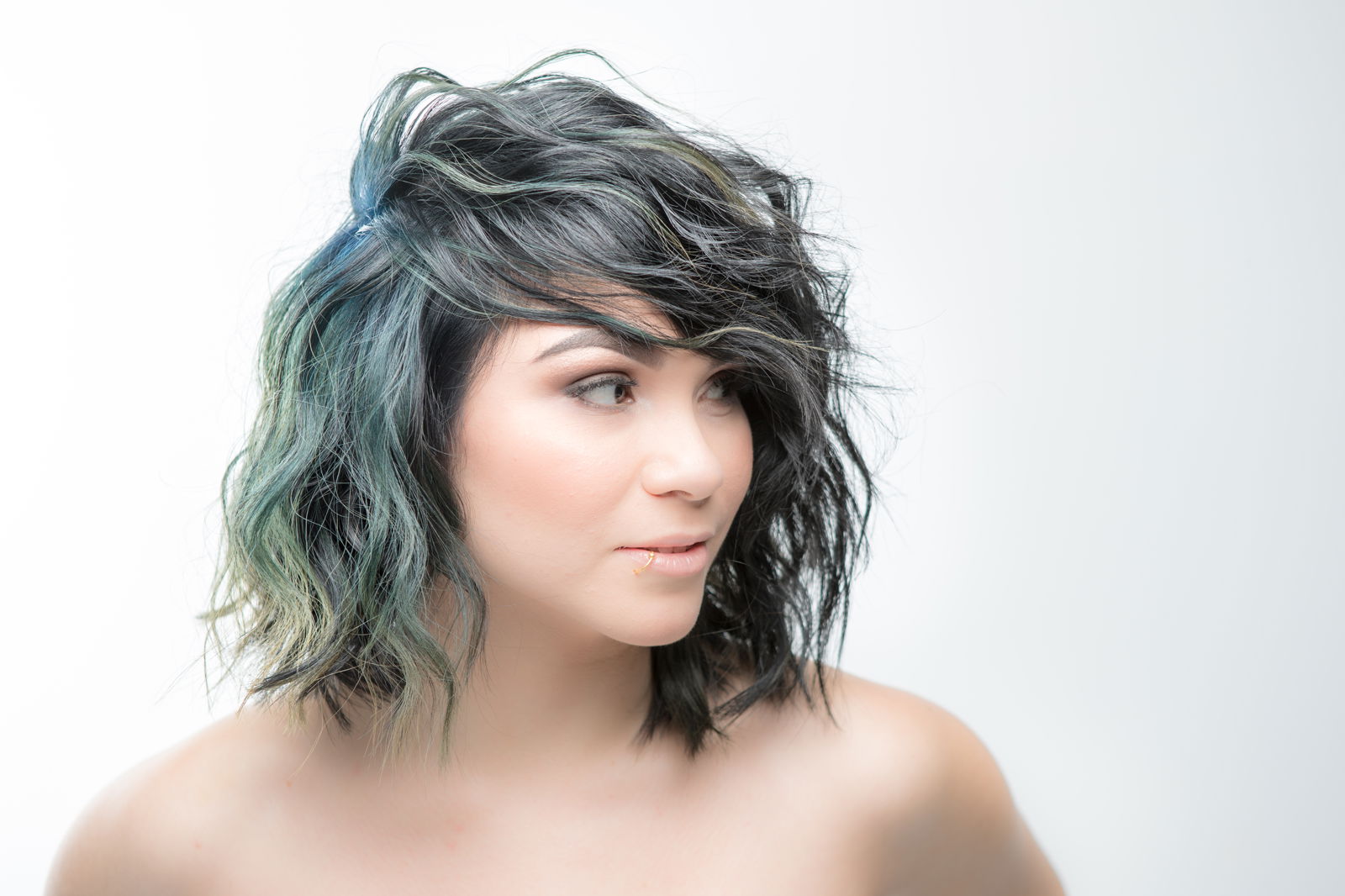 Shoulder-length tousled bob with a wash of green through it.